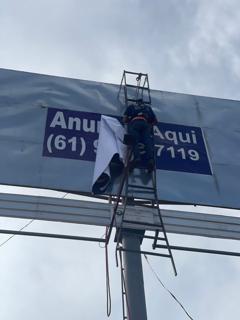 Aplicação de lona 'Anuncie Aqui' em outdoor